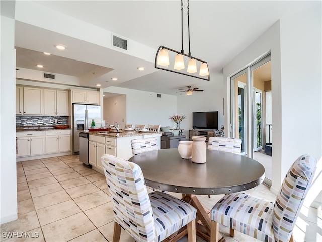 tiled dining area featuring sink and ceiling fan