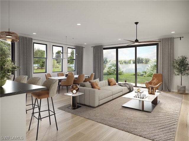 living room with light hardwood / wood-style floors, a water view, and ceiling fan