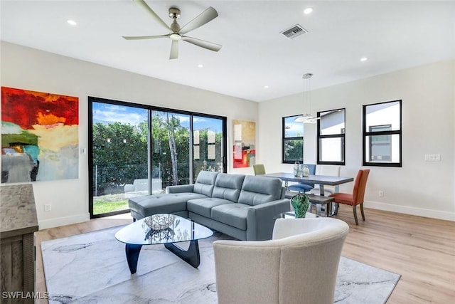 living room with visible vents, a ceiling fan, recessed lighting, light wood-style floors, and baseboards