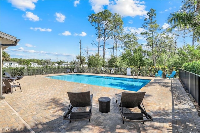 pool with a patio and fence