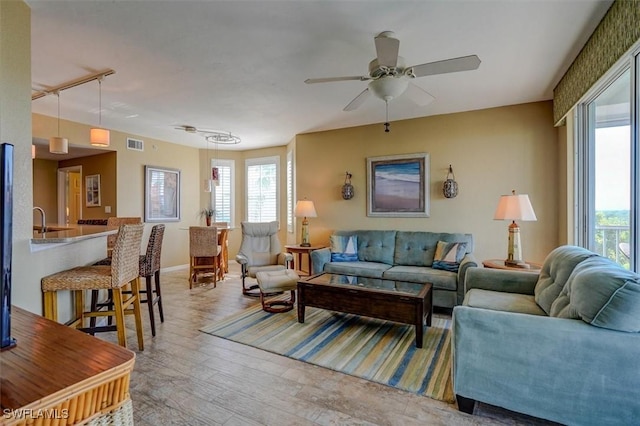 living room featuring ceiling fan, hardwood / wood-style flooring, and a healthy amount of sunlight