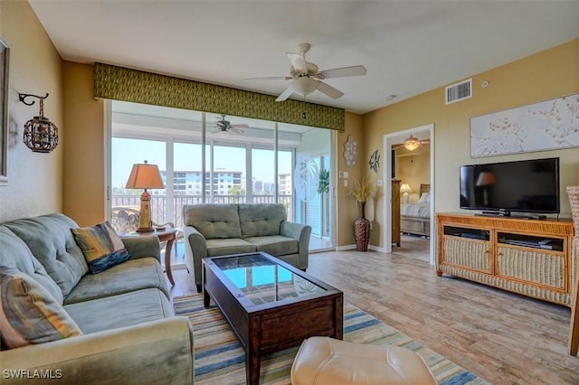 living room with light hardwood / wood-style flooring and ceiling fan