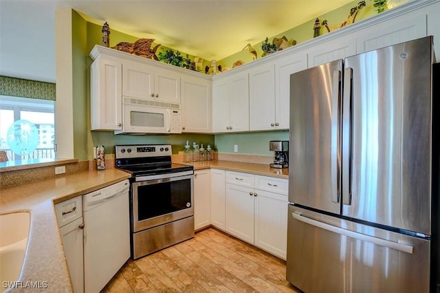 kitchen with stainless steel appliances, light wood-type flooring, and white cabinets