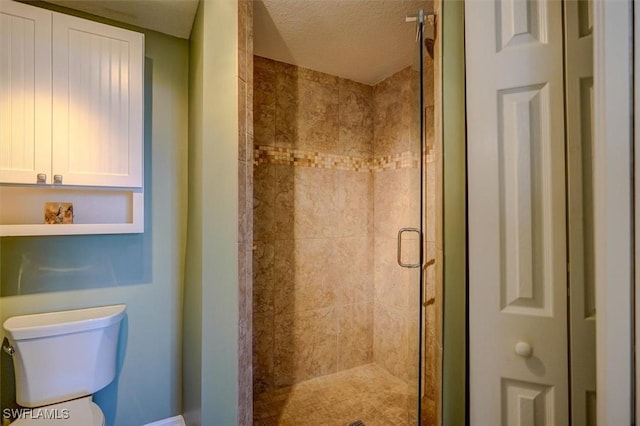 bathroom with a shower with door, a textured ceiling, and toilet