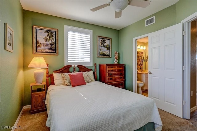 bedroom featuring ceiling fan, light colored carpet, and ensuite bathroom