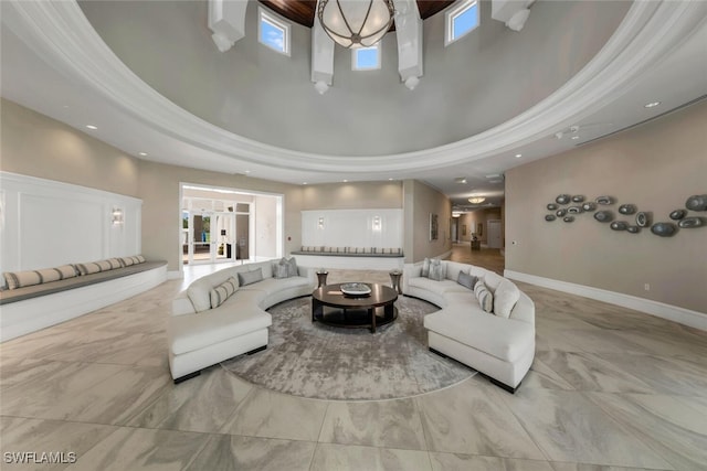 living room featuring a high ceiling, ornamental molding, and a tray ceiling