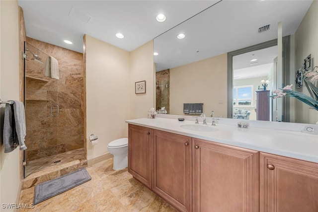 bathroom featuring vanity, toilet, and a shower with shower door