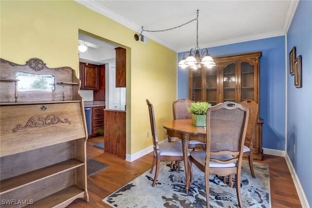 dining area featuring a notable chandelier, dark wood-type flooring, and ornamental molding