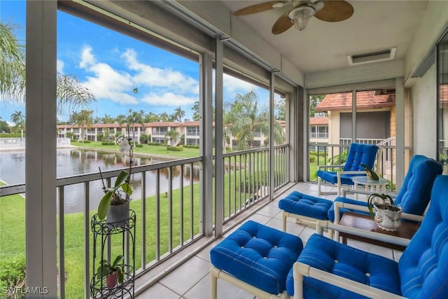 sunroom with a water view and ceiling fan