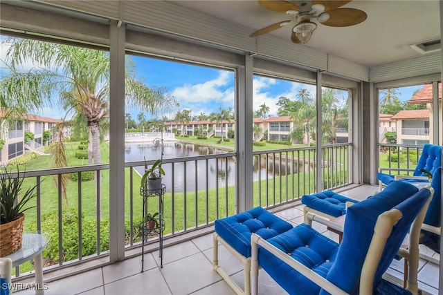 sunroom / solarium featuring a water view and ceiling fan