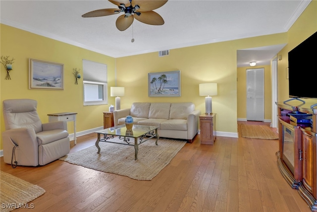 living room featuring ornamental molding, ceiling fan, and light wood-type flooring