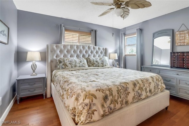 bedroom with dark wood-type flooring, ceiling fan, and a textured ceiling