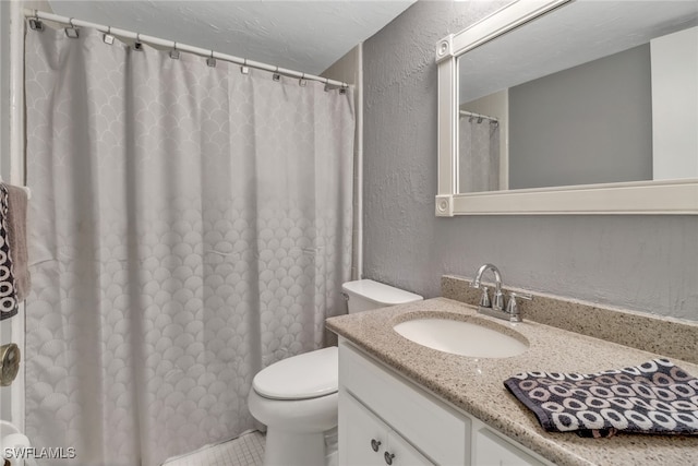 bathroom featuring vanity, a textured ceiling, and toilet