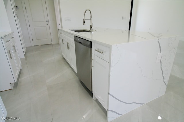 kitchen featuring dishwasher, sink, white cabinets, a center island with sink, and light stone countertops