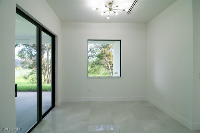 spare room with a notable chandelier