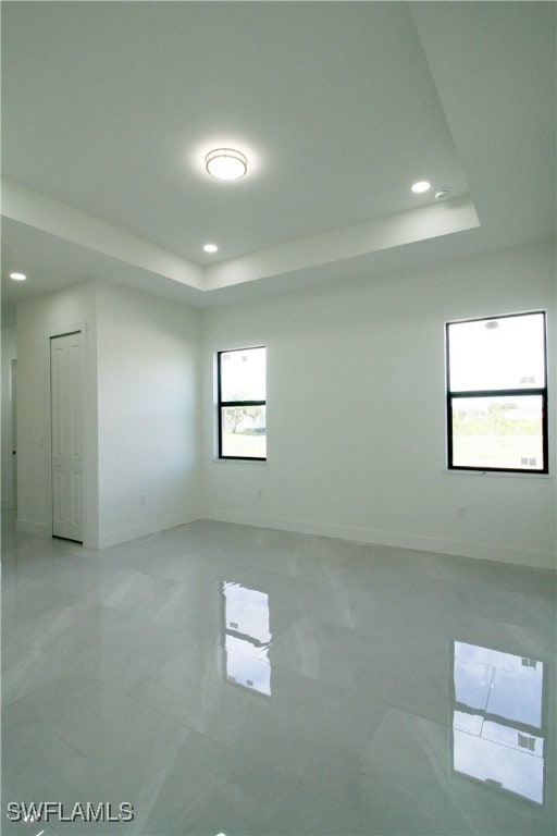 unfurnished room with a tray ceiling