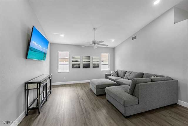 living room with dark hardwood / wood-style flooring, vaulted ceiling, and ceiling fan