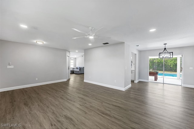 unfurnished living room featuring ceiling fan and dark wood-type flooring