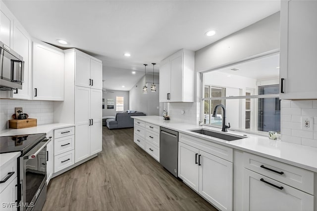 kitchen with a healthy amount of sunlight, dark hardwood / wood-style flooring, white cabinetry, and stainless steel appliances