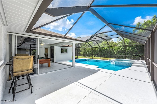 view of swimming pool featuring an in ground hot tub, glass enclosure, ceiling fan, and a patio area