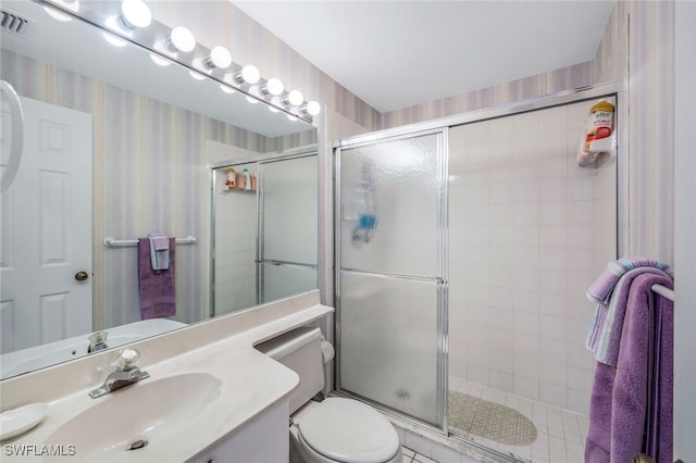 bathroom featuring vanity, toilet, and walk in shower