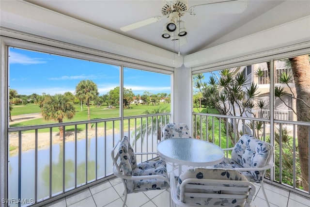 sunroom / solarium featuring a water view, ceiling fan, vaulted ceiling, and a wealth of natural light