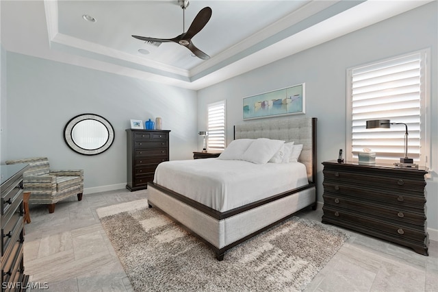 tiled bedroom with ceiling fan and a tray ceiling