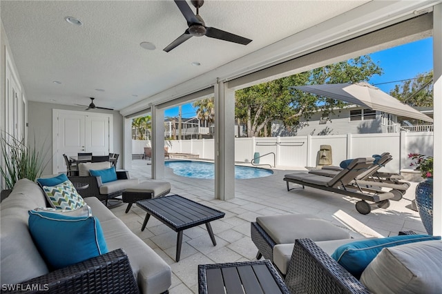 view of patio / terrace featuring an outdoor living space, ceiling fan, and a fenced in pool