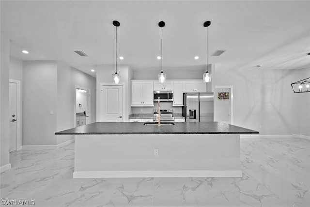 kitchen featuring a center island with sink, visible vents, a sink, stainless steel appliances, and white cabinets