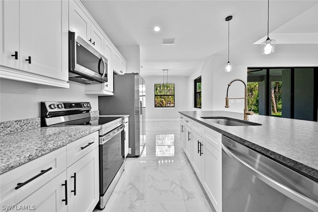 kitchen featuring stainless steel appliances, sink, pendant lighting, light tile patterned floors, and white cabinetry