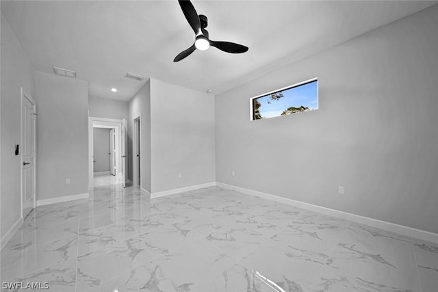 unfurnished room with visible vents, ceiling fan, marble finish floor, and baseboards