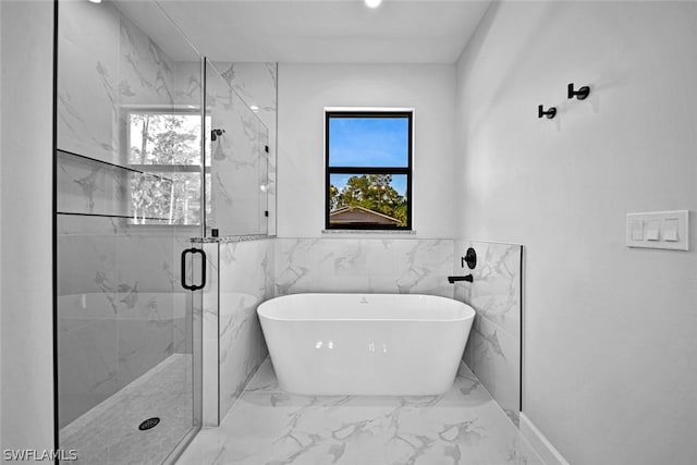 full bathroom with marble finish floor, a marble finish shower, and a freestanding bath