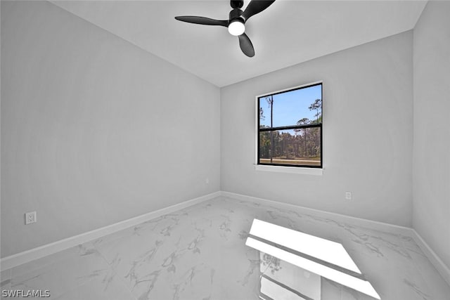 unfurnished room with ceiling fan, marble finish floor, and baseboards