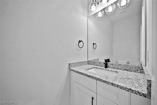 bathroom with visible vents, toilet, and vanity