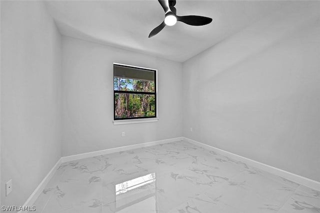 spare room with baseboards, marble finish floor, and a ceiling fan