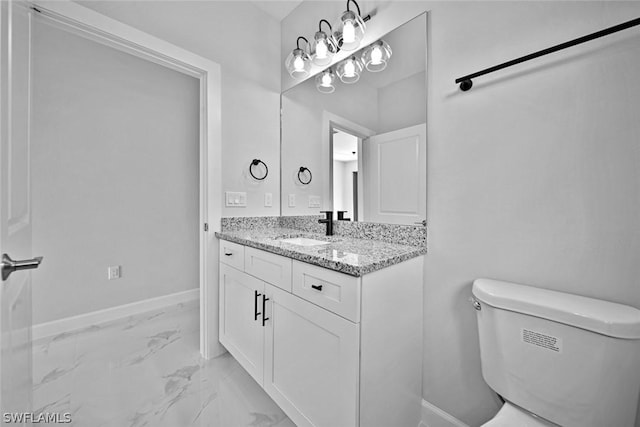 bathroom with baseboards, toilet, marble finish floor, and vanity