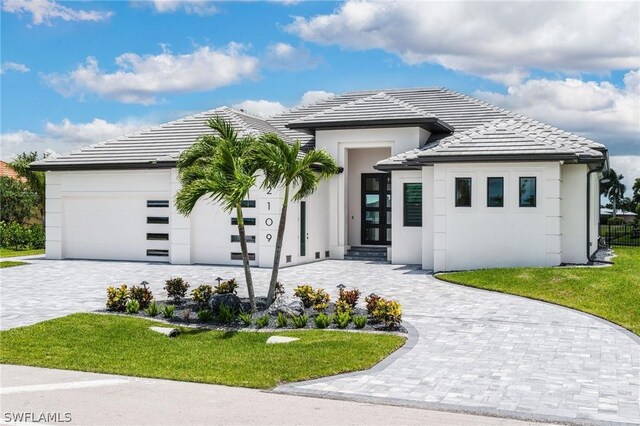 view of front of home with a garage and a front lawn