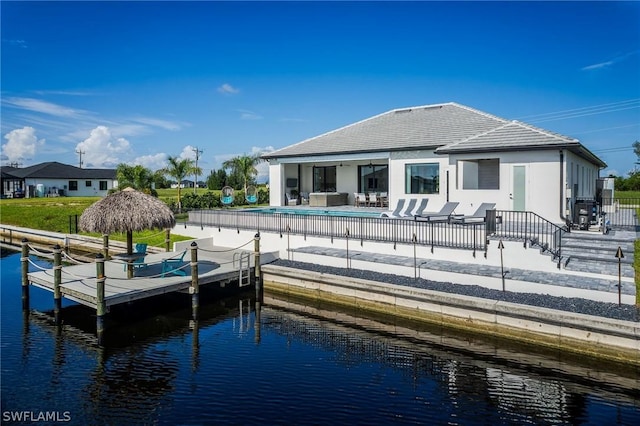 back of property featuring a water view, a fenced in pool, and a patio area