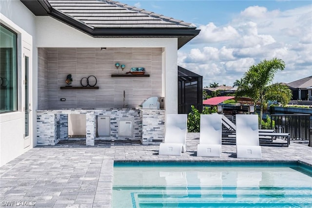 view of pool with a patio, a grill, area for grilling, a lanai, and a water view