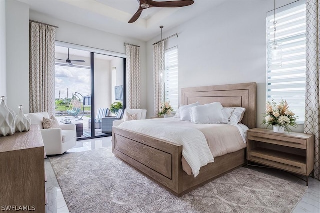 bedroom featuring multiple windows, access to exterior, and ceiling fan