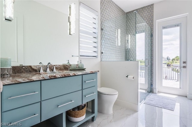 bathroom with a shower with door, vanity, and toilet