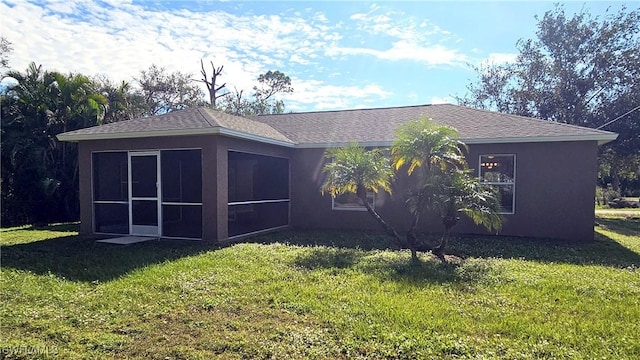 rear view of property with a yard and a sunroom