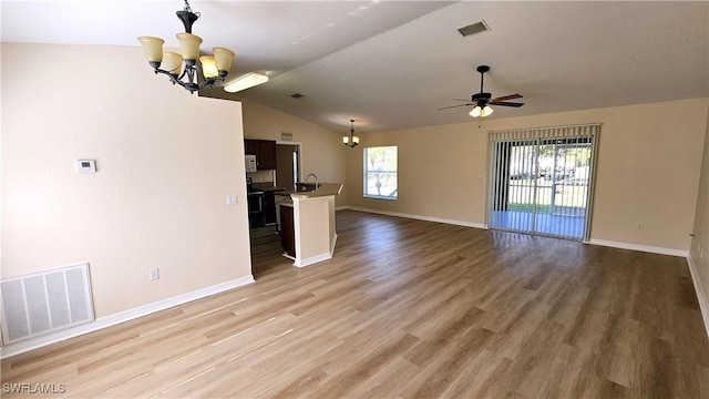 unfurnished living room with hardwood / wood-style flooring, ceiling fan with notable chandelier, lofted ceiling, and sink