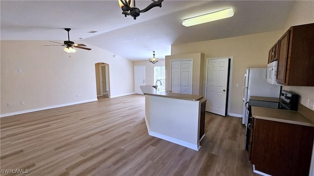 kitchen with wood-type flooring, ceiling fan with notable chandelier, dark brown cabinets, and lofted ceiling