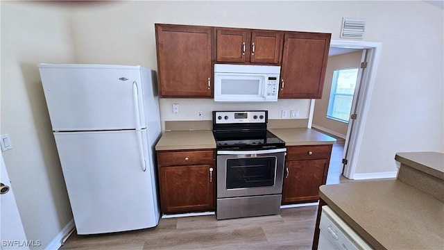 kitchen featuring light hardwood / wood-style floors and white appliances