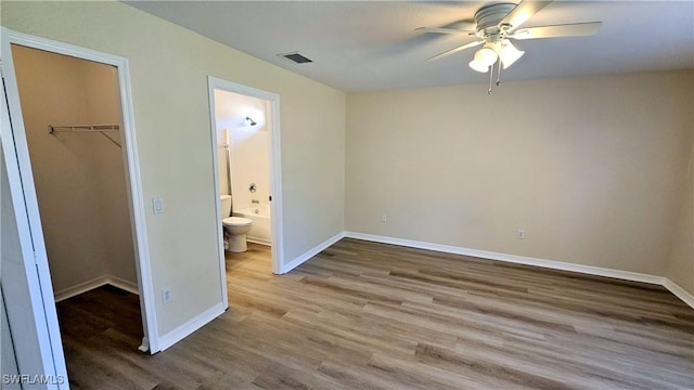 unfurnished bedroom with connected bathroom, ceiling fan, a closet, and light hardwood / wood-style floors