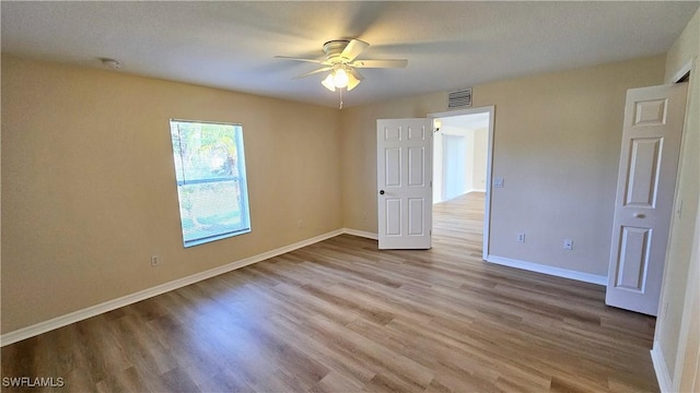 unfurnished bedroom with a textured ceiling, light hardwood / wood-style flooring, and ceiling fan