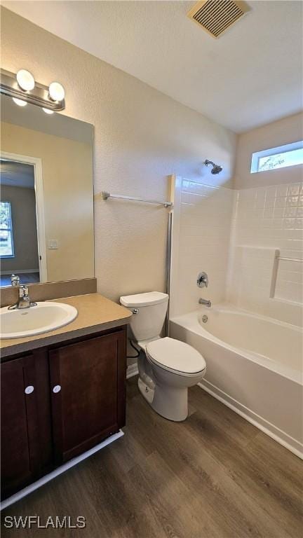 full bathroom with wood-type flooring, vanity, toilet, and tiled shower / bath