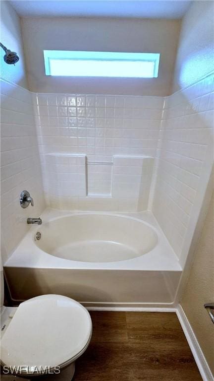 bathroom with a wealth of natural light, hardwood / wood-style floors, shower / bathing tub combination, and toilet