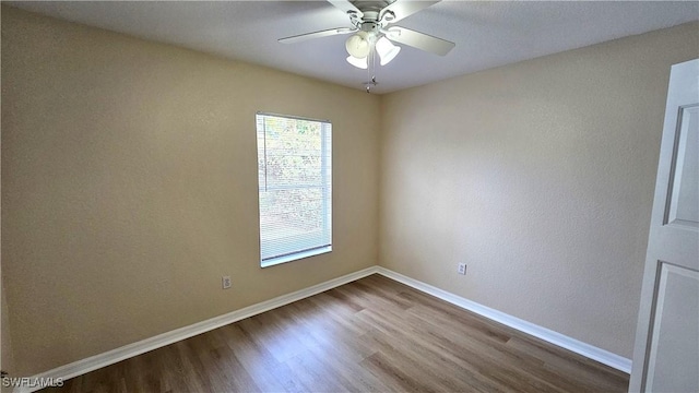 spare room with ceiling fan and wood-type flooring